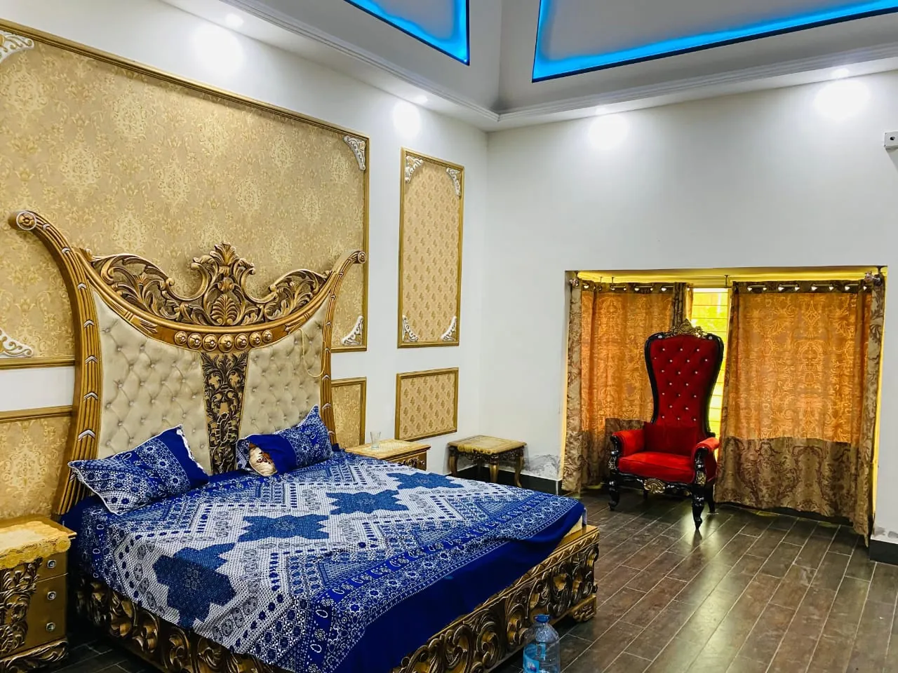 Master bedroom with a carved double bed, a throne chair and ceiling lighting